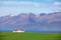 Nei dintorni di Seydisfjordur, Islanda, basta avere un tetto rosso per risaltare sul paesaggio verde e blu - © Max Topchii / Shutterstock.com