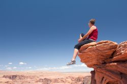Foto di una turista sul bordo del precipizio del Grand Canyon, che si trova in Arizona (Usa) - © T-Design / Shutterstock.com
