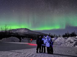 Foto di gruppo durante una magnifica aurora boreale ad Abisko in Svezia