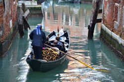 Gondola con turisti in un canale del centro  di ...