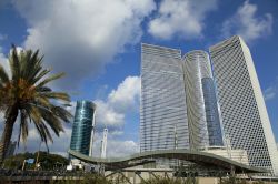 Tre grattacieli di Tel Aviv (Israele) e ai loro piedi il tetto ondulato della stazione ferroviaria di HaShalom. Gli edifici moderni dimostrano la grande crescita vissuta negli ultimi decenni ...