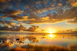 Un magnifico tramonto sul mare di La Réunion, l'isola dell'arcipelago mascareno appartenente alla Francia immersa nell'Oceano Indiano a est del Madagascar - © infografick ...