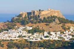 Il fascino di Lindos sull'isola di Rodi, Grecia - Il centro abitato di Lindos con alle spalle l'acropoli che sorge su una collina a precipizio sul mare alta 116 metri. La rupe ospita ...