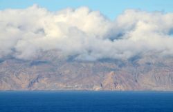La costa arida di Ilha Brava a Capo Verde. Il vento dall'oceano, risalendo sulle montagne, spesso le incappuccia in una cortina di nubi permanenti - © Raul Rosa / Shutterstock.com