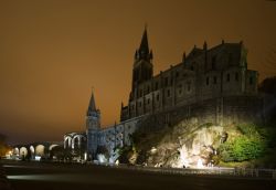 La grotta di Bernadette a Lourdes, dove avvennero le apparizioni, ed il vicino Santuario - © sursad / Shutterstock.com