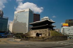 La vecchia porta di Namdaemun: il suo stile pagoda contrasta fortemente con gli edifici del centro moderno di Seoul la moderna  capitale della Corea del Sud (South Korea) - © Pete ...
