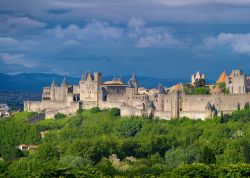 Carcassonne, Linguadoca-Rossiglione, Francia meridionale: mura possenti, torri difensive e una grande luna piena nel cielo all'imbrunire... non è il paesaggio ideale per cavalieri ...