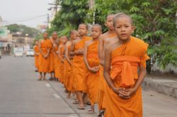 Monaci del tempio Wat Thung Si Meuang, Ubon Ratchathani - Ogni giorno, con indosso la loro tunica arancione, i giovani monaci escono dal monastero Wat Thung Si Meuang, edificato durante il regno ...