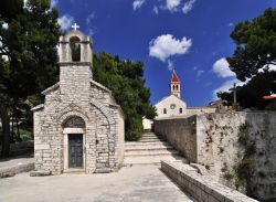 Monastero di Bol sull'Isola di Brac in Croazia: la cappella Sant Ivano e Teodoro, la chiesa del 1475 sullo sfondo - © Mirvav / Shutterstock.com