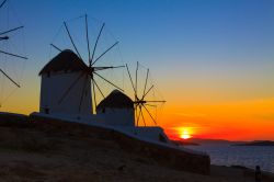 Mulini a vento a Mykonos al tramonto: s'incendia il cielo delle Cicladi e della Grecia - © Vasilis Barbounakis / Shutterstock.com