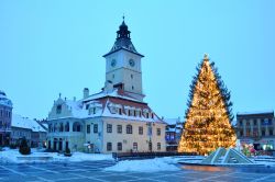 Municipio Brasov a Natale, Romania - Neve sui tetti del Municipio di Brasov illuminato dalle luci e dalle decorazioni del maestoso albero di Natale che svetta in piazza del Consiglio dove gli ...