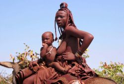 Namibia:nella savana vicino al parco di  Etosha, una donna Himba con bimbo - Foto di GIulio Badini