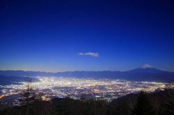 Il magnifico panorama notturno con monte Fuji. In basso le luci delle città della prefettura di Yamanashi, che si trova a nord della montagna sacra del Giappone - © Norikazu / ...