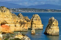 Pinnacoli di roccia si tuffano nel mare pulito di Lagos in Algarve (Portogallo) - © astudio / Shutterstock.com