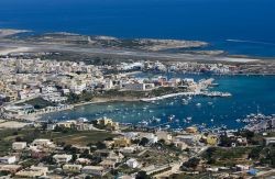 Il Porto e la città di di Lampedusa e sullo sfondo la pista dell'aeroporto che serve l'arcipelago delle isole Pelagie, a sud-est della Sicilia, nel cuore del mar Mediterraneo ...