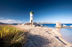 Faro a Punta Palau, nel nord della Sardegna, di fronte all'Arcipelago della Maddalena: roccia, sabbia, qualche ciuffo di macchia mediterranea e il turchese del mare disegnano un paesaggio ...