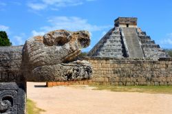 Una Scultura nel sito Maya di Chichen itza: sullo sfondo la piramide a gradoni di El Castillo, uno dei simboli dello Yucatan e del Messico intero - © alexsvirid / Shutterstock.com