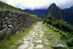 Sentiero dell'Inca trekking verso Machu Picchu, Perù - Il contrasto fra il biancoazzurro del granito e il verde dell'erba che ricopre i terrazzamenti agricoli sui pendii crea ...