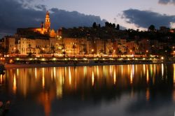 La skyline di Menton, di notte visibili i riflessi ...