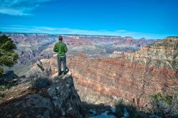South Rim, ovvero il versante meridionale del Grand Canyon in Arizona: un uomo sul precipizio ammira uno degli spettacoli più impressionanti della terra - © ClimberJAK / Shutterstock.com ...