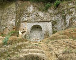 Tomba della Sirena a Sovana, Toscana. Questa bella sepoltura a edicola, scavata interamente nel tufo, si presenta con una facciata che riproduce una finta porta sormontata da un arco che regge ...