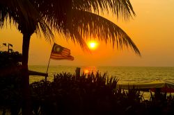 La bella spiaggia Batu Ferrenghi a Penang: una luce calda avvolge la bandiera malese (Malaysia) - ©  Shaun Robinson / Shutterstock.com