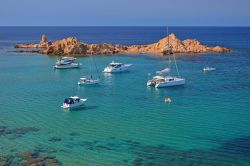 Minorca, Baleari: una serie di scogli che affiorano di fronte a Cala Pregonda forma una sorta di barriera che dà un sapore ancora più intimo e protetto alla spiaggetta. L'acqua ...