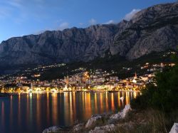La costa di Makarska, in Croazia: vista notturna della città e dei monti del massiccio del Biokovo alle spalle della riviera - © emberiza / Shutterstock.com