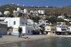La spiaggia di Pandeli a Leros, con i mulini a vento a fare da suggestiva cornice sullo sfondo. Le case bianche e dalle tonalità pastello rendono unico questo villaggio greco composto ...