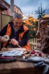 Un artigiano scolpisce il legno in un mercatino dell'Avvento a Villach, Austria © Hannes Pacheiner
