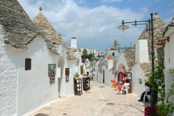 Strada dentro Alberobello, con le tipiche geometrie dei trulli di Puglia - © Pixachi / Shutterstock.com