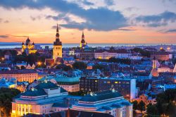 I tetti di Tallinn, capitale estone, si tingono di rosa e azzurro al tramonto, mentre iniziano ad eccendersi le luci romantiche della sera - © Oleksiy Mark  / Shutterstock.com