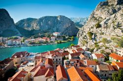 I tetti rossi di Omis contrastano con il Canyon della Cetina, che qui si tuffa, dalle montagne calcaree dell'interno, nel mare Adriatico - © alexdrim / Shutterstock.com