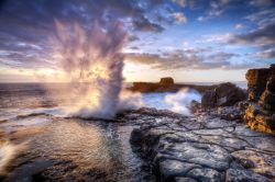 Un "blowhole" al tramonto lungo la costa dell'isola di Réunion (Isole Mascarene, Francia). Per i geologi un “blowhole” è uno sfiatatoio di grotte ...