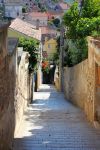 Via tipica di Losinj, Croazia - Vicoletti a tratti tortuosi con scalinate che convergono sulla cima della collina, dove si trova l'immancabile chiesa con il campanile in stile veneziano, ...