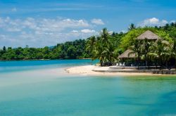 L'acqua azzurra del mare delle Andamane a Koh Payam, Ranong, Thailandia. Sullo sfondo, un tratto di foresta tropicale.

