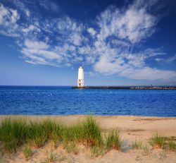 L'acqua blu del lago Michigan e la spiaggia di sabbia nei pressi del faro di Frankfort, Stati Uniti d'America, in una mattina d'estate.

