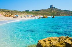 L'acqua cristallina lambisce una spiaggia di San Giovanni di Sinis, Sardegna. Lungo i 30 chilometri di costa dell'area protetta s'immergono nel mare turchese spiagge di finissimi ...