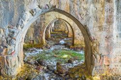 Alanya, Turchia: le rovine di un cantiere navale di epoca medievale con le onde incise sugli archi in pietra.

