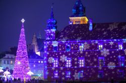Albero di Natale illuminato nella piazza centrale di Varsavia (Polonia). A creare l'atmosfera natalizia sono anche le luci colorate proiettate sulle facciate dei palazzi storici.
