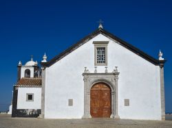 Antica chiesa a Cacela Velha in Algarve, Portogallo - Un caratteristico edificio religioso nella cittadina di Cacela Velha: il bianco della facciata si contrappone al blu del cielo e dell'acqua ...
