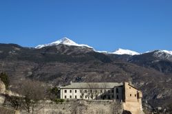 Un'antica costruzione della cittadina di Susa, Piemonte, con le cime innevate dei monti sullo sfondo.

