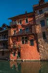 Antichi palazzi nel centro storico di Annecy, Francia. Fotografati dal lato opposto del canale, sono illuminati dalla luce calda del tramonto.

