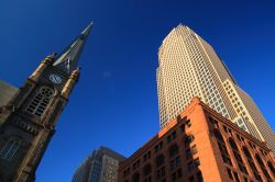 Antico e moderno nella città di Cleveland, Ohio, USA: un campanile in stile gotico con orologio e un futuristico grattacielo.

