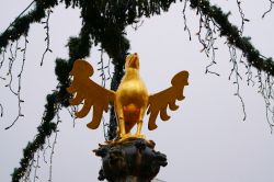 L'aquila imperiale medievale di Goslar nel centro storico cittadino (Germania). Sullo sfondo, le luminarie decorano un albero durante il tradizionale mercato natalizio - © K I Photography ...