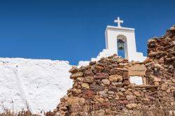 Architettura religiosa in un villaggio dell'isola di Kimolos, Grecia: particolare di un campanile con croce e campana.

