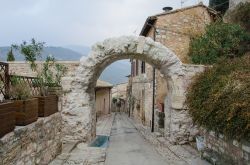 Arco di epoca romana nella città di Spello, Umbria. I resti della cinta muraria così come quelli archeologici che la circondano attestano la grandezza e l'importanza che questa ...