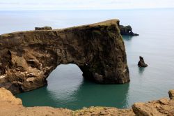 L'arco di lava nera sul mare nel promontorio di Dyrholaey, Vik i Myrdal, Islanda.  Siamo sulla costa sud del paese dove si estende questa penisola di origine vulcanica. Proprio di fronte ...