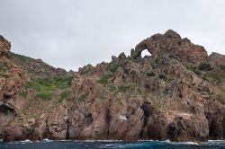 Un arco naturale tra le rocce di Scandola, Corsica - hanno le forme più strane le rocce delle scogliere di Scandola, scolpite nel tempo dal processo erosivo dell'acqua. A popolare ...