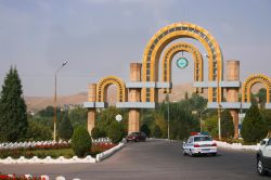 Auto in una strada della città di Dushanbe (Tagikistan). Sullo sfondo, l'arco d'ingresso e le montagne Pamirs - © Viktoria Gaman / Shutterstock.com